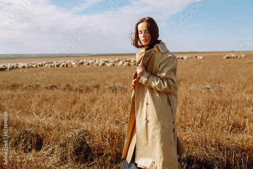 Stylish young woman posing in a field. Fashion, glamour, lifestyle concept. Autumn.