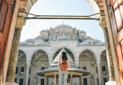Canvas Print A young female traveler with a backpack on her back walks towards the Fatih Mosq