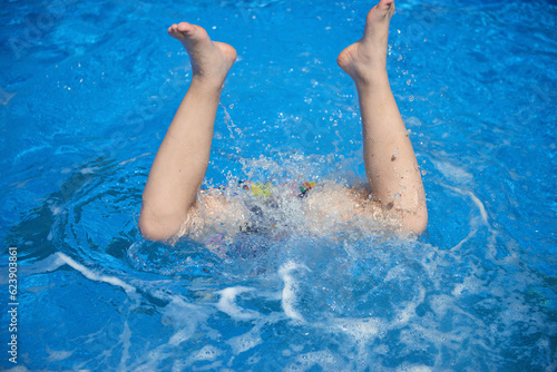 Fit swimmer training in the swimming pool. An overhead view of a man diving into a pool, forming an arrow shape and leaving a trail behind him. Professional male swimmer inside swimming pool. Young