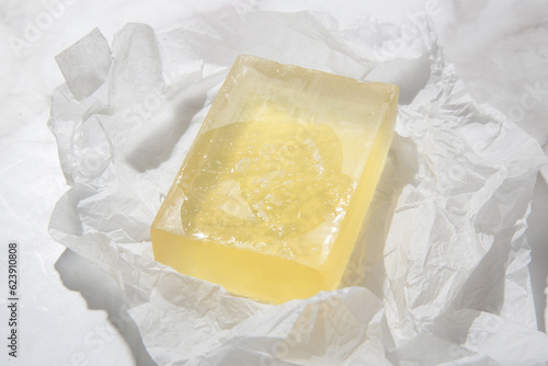 Natural bar soap for healthy skin and hair. Hydrating cleansing bar on crumpled package paper 