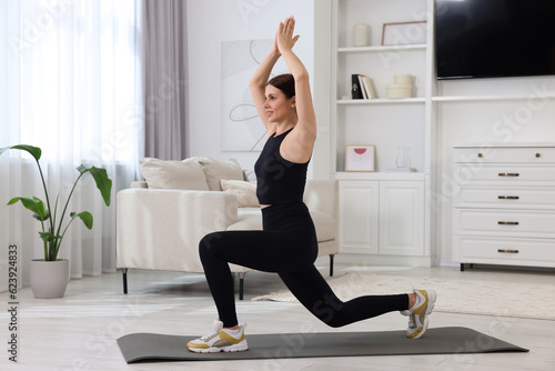 Morning routine. Happy woman stretching at home