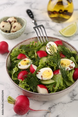 Delicious salad with radish, lettuce and boiled quail eggs served on white marble table, closeup