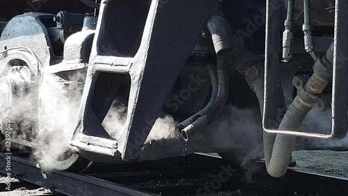 Steam of working locomotive close up. Historical museum exhibition of old retro depot with collection of vintage trains. Railway workers day