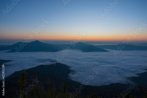 Fototapeta Naklejka Na Ścianę i Meble -  Beautiful landscape on the mountains against sky during sunrise. Spectacular view in foggy valley covered forest under morning sky. Countryside landscape view background.