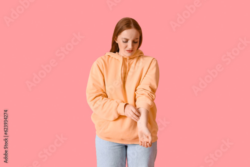 Allergic young woman scratc...