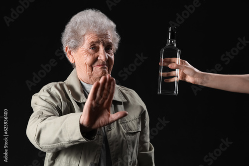 Senior woman rejecting bott...