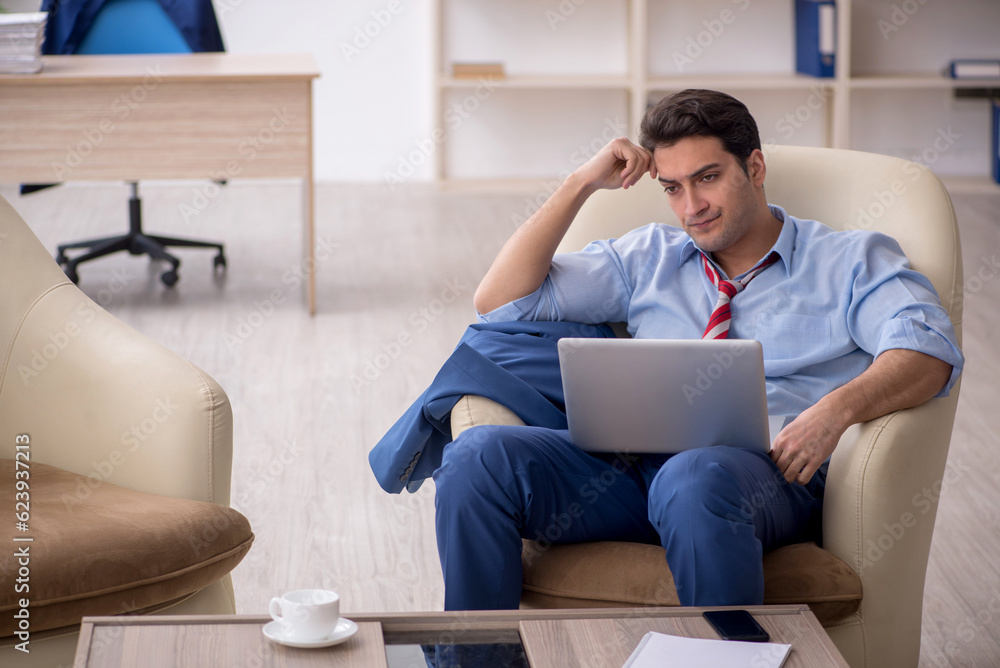 Young male employee sitting in the office Young male employee sitting in the office