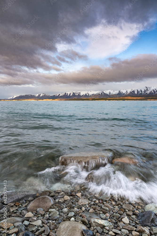 Scenic sunrise view of Lake Pukaki, with their mesmerizing turquoise hue and reflect the majestic snow-capped Southern Alps. Perfect for travel brochures, nature magazines, and inspirational content.