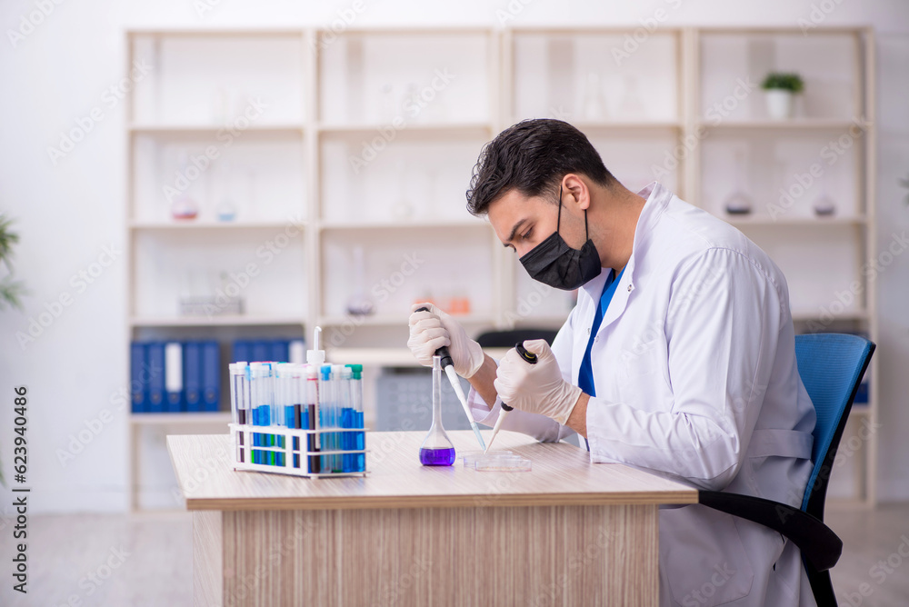 Young male chemist working at the lab Young male chemist working at the lab
