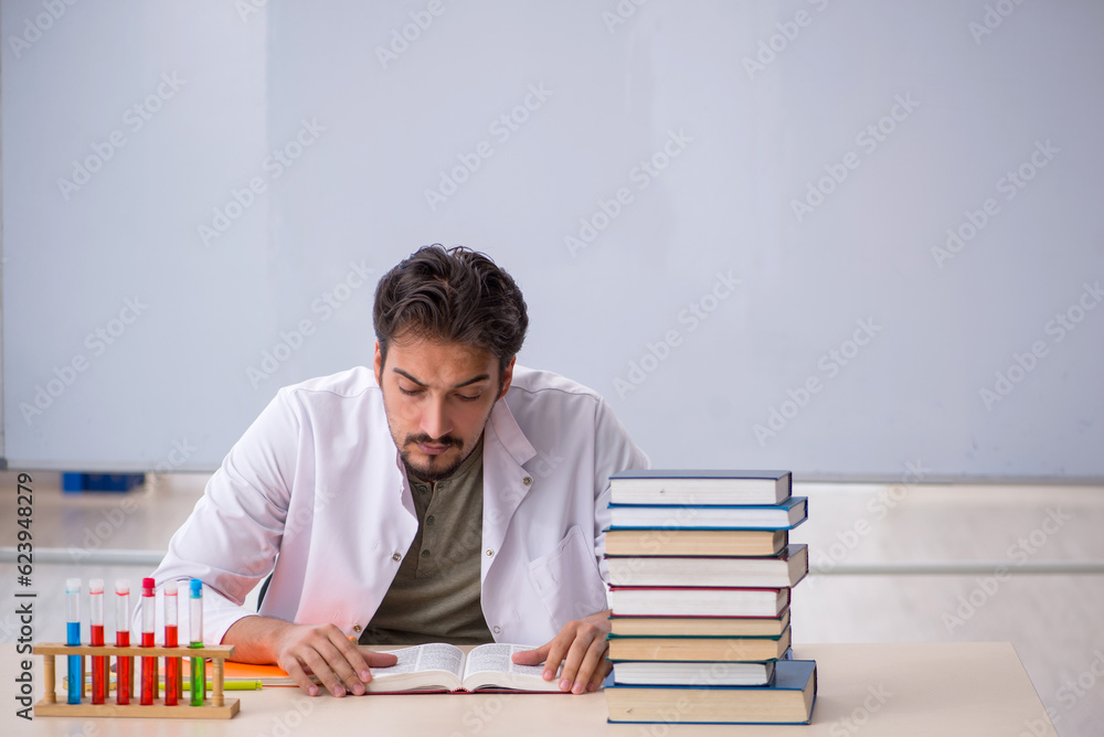 Young male chemist teacher in front of whiteboard Young male chemist teacher in front of whiteboard