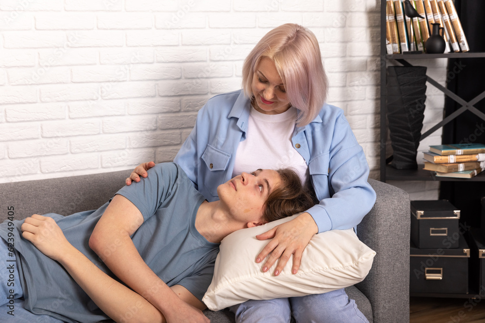Happy middle age mother spend time with teenager son, relatives people hugging at home, adult attentive millennial grateful child and loving mommy Happy middle age mother spend time with teenager son, relatives people hugging at home, adult attentive millennial grateful child and loving mommy
