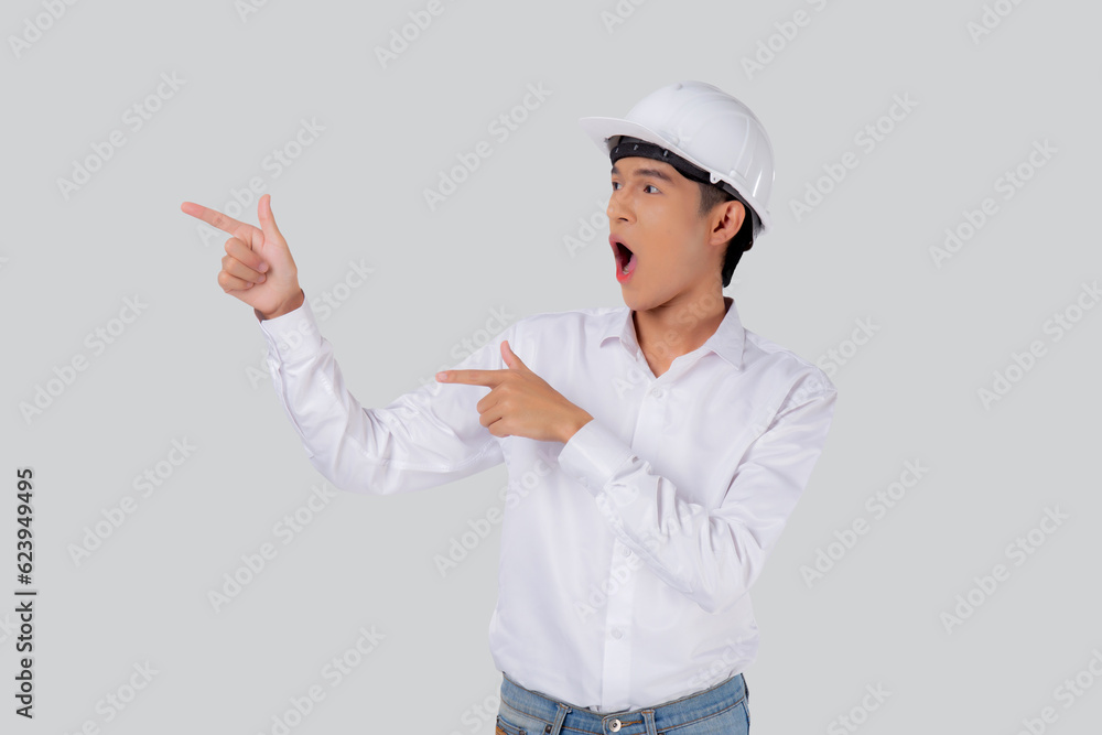 Portrait young asian man is engineer wearing helmet standing and excited isolated white background, male is architect or contractor presenting or showing something with shocked, industrial concept. Portrait young asian man is engineer wearing helmet standing and excited isolated white background, male is architect or contractor presenting or showing something with shocked, industrial concept.