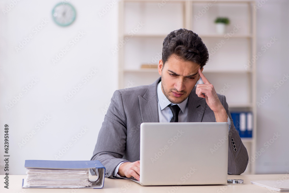 Young male employee working in the office Young male employee working in the office
