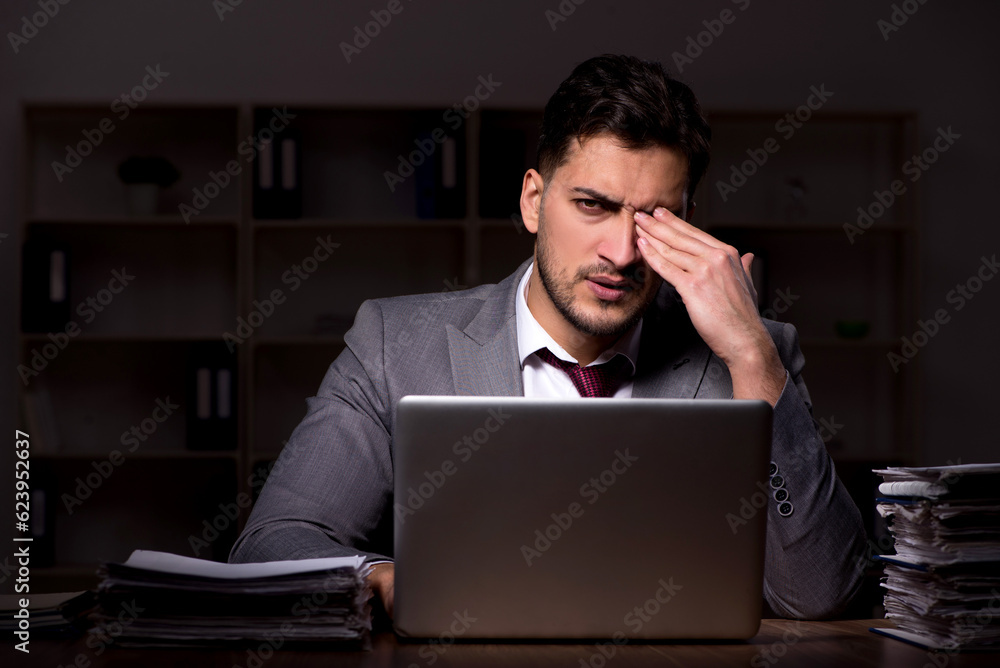 Young male employee working late in the office Young male employee working late in the office