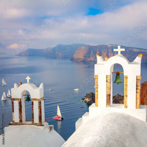 Santorini, Greece. White bell arch and blue sea view with boats. Conceptual composition of the famous architecture of Santorini island. Santorini minimalist photo collection.