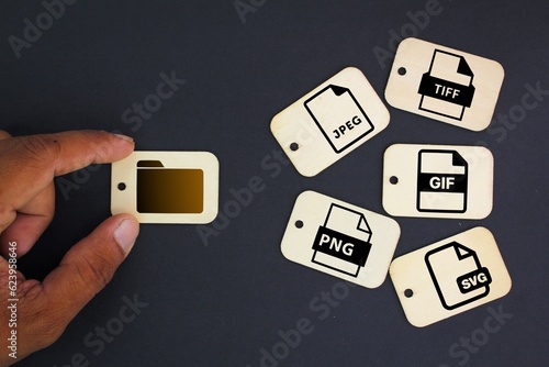 Tag wood with icons of 5 types of image files namely JPEG, PNG, GIF, TIFF and SVG. The concept of saving files in the form of an image