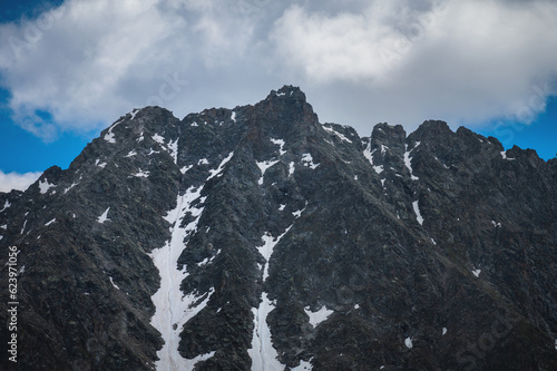 Fototapeta Naklejka Na Ścianę i Meble -  Close up, snowy mountain with bright blue sky and white cloud. Big mountain peak covered with snow