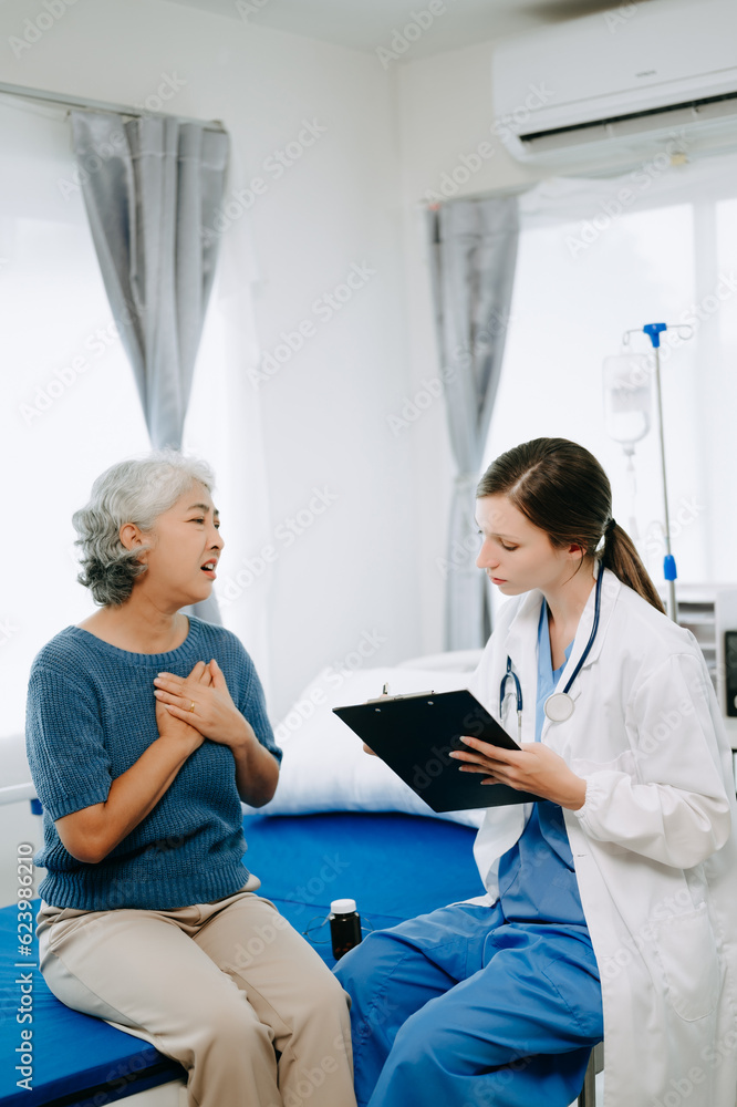 Obraz premium Friendly Female Head Nurse Making Rounds does Checkup on Patient Resting in Bed. She Checks tablet while Man Fully Recovering after Successful Surgery in hospital.