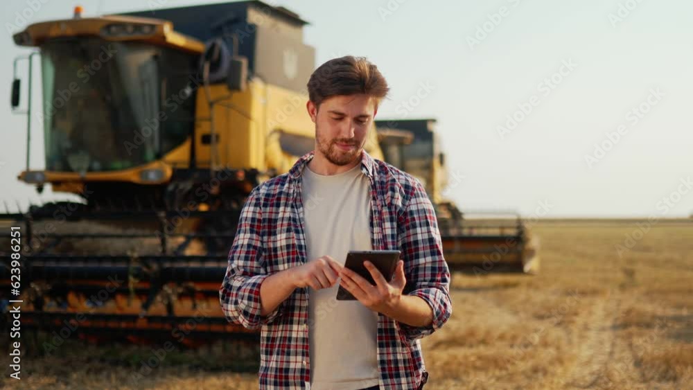 Agronomist uses modern technologies in agriculture, yield map apps at wheat field. Precision smart farming. Farmer use digital tablet for combine harvester guidance and control with automation system. Agronomist uses modern technologies in agriculture, yield map apps at wheat field. Precision smart farming. Farmer use digital tablet for combine harvester guidance and control with automation system.
