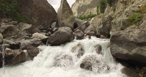 Drone footage of flowing river in the northern Pakistan gilgit baltistan Pakistan beautiful view of flowing river thorough mountains and rocks nature background  photo