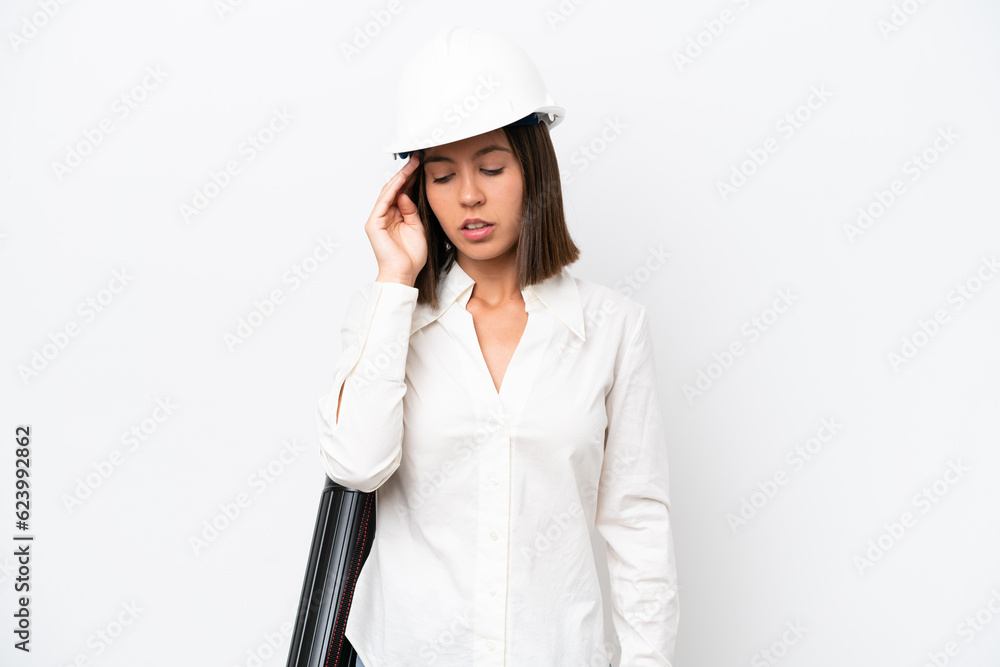 Young architect woman with helmet and holding blueprints isolated on white background with headache Young architect woman with helmet and holding blueprints isolated on white background with headache