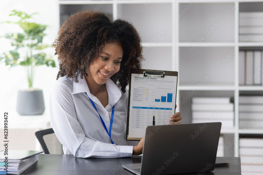 Young African American businesswoman cheerfully celebrate success at office desk in office, analysis data the charts, online tired, business finance and accounting concept. Young African American businesswoman cheerfully celebrate success at office desk in office, analysis data the charts, online tired, business finance and accounting concept.