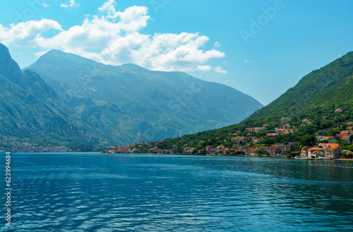 seascapes  a view of the Bay of Kotor during a cruise on a ship in Montenegro  a bright sunny day  mountains and small towns on the coast  the concept of a summer trip