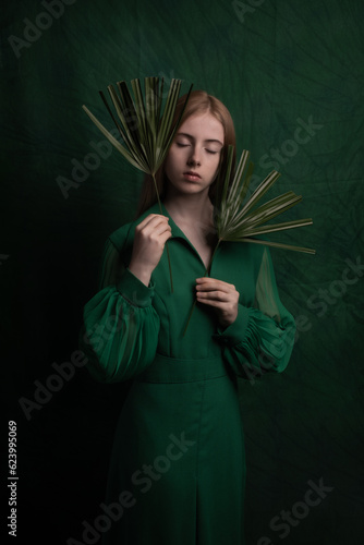 classic art portrait of a woman in green dress holding leaves in renaissance style photo