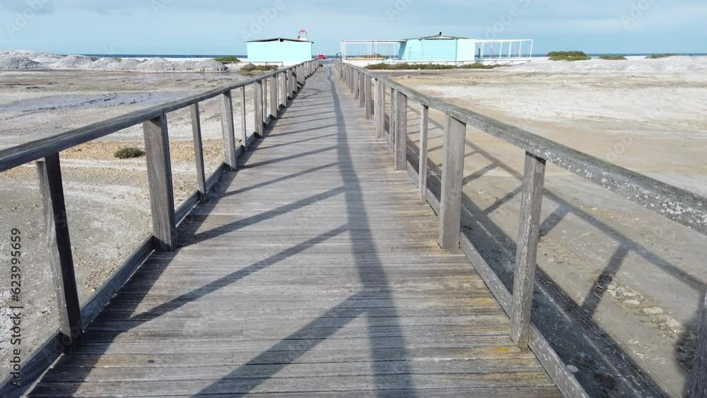 The wooden bridge over the salt marshes that leads to one of the Sardinian beaches. The wooden bridge over the salt marshes that leads to one of the Sardinian beaches.
