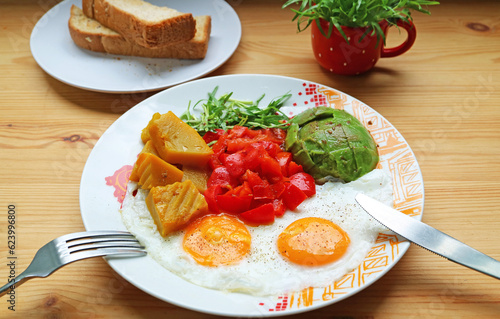 Healthy breakfast of a pair of sunny side up with colorful vegetable salad