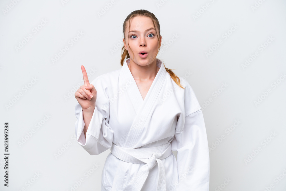 Young caucasian girl doing karate isolated on white background intending to realizes the solution while lifting a finger up Young caucasian girl doing karate isolated on white background intending to realizes the solution while lifting a finger up