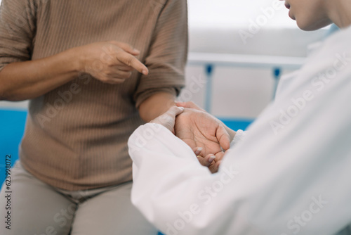 Physical injury treatment: Serious doctors are analyzing fracture patients. elderly with broken arm talking to trauma doctor or orthopedic surgeon during physical examination in hospital or clinic.