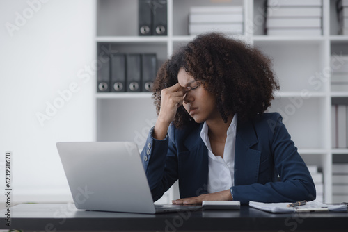 African American businesswoman are stressed and tired from work sitting at desk in the office, feeling sick at work, stress from work. 