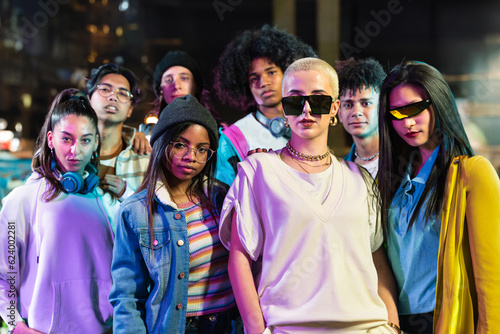 Group of trendy friends in modern funky style looking to camera in the city at night - Young Music Video Dance