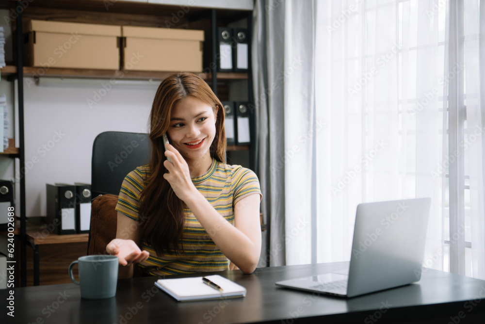 Young attractive Asian woman smiling thinking planning writing in notebook, tablet and laptop working from home at office . Young attractive Asian woman smiling thinking planning writing in notebook, tablet and laptop working from home at office .