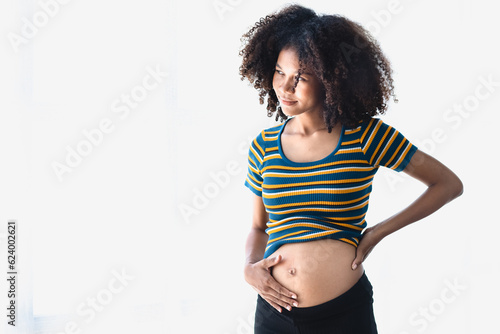 Happy young pregnant African American woman standing on white background.