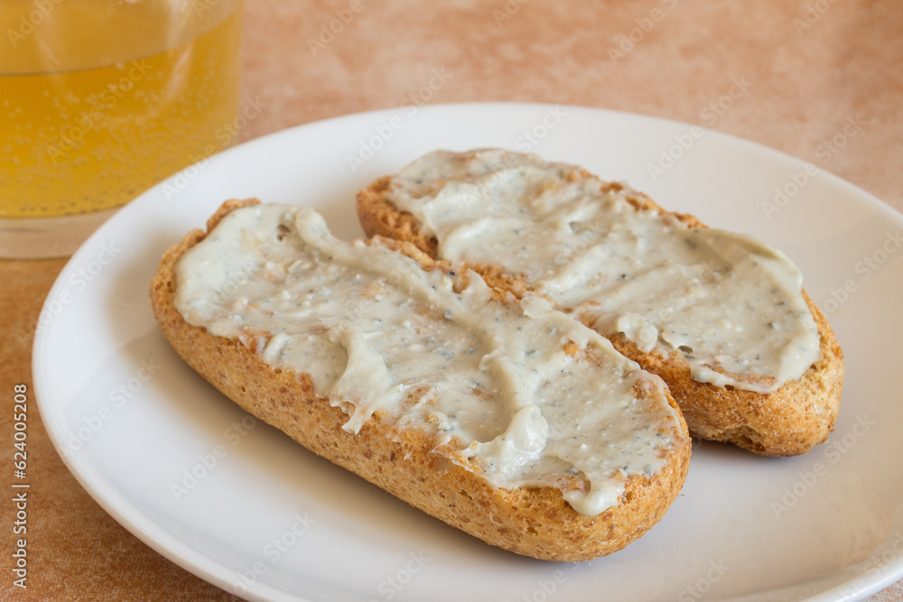 Close-up of Cabrales cream on toasted wholemeal bread with a shot of cider in the background. Traditional Spanish recipes and blue cheese.