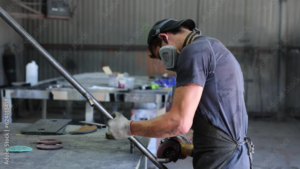 Metalworking workshop. The master grinds the metal with a grinding machine. Sparks Metalworking workshop. The master grinds the metal with a grinding machine. Sparks