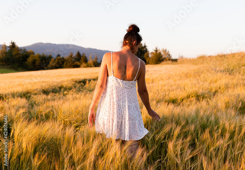 Woman between golden barley fields, country life, rest in rural nature © PhotoHunter