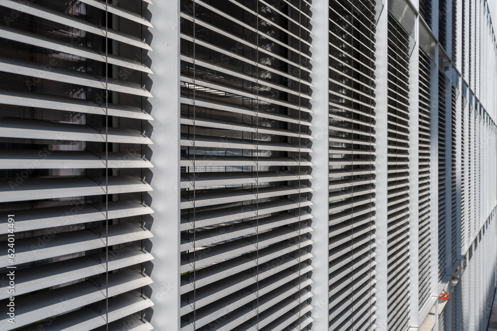 closed automated external Venetian blinds protecting an office building from sunlight and heat. closed automated external Venetian blinds protecting an office building from sunlight and heat.
