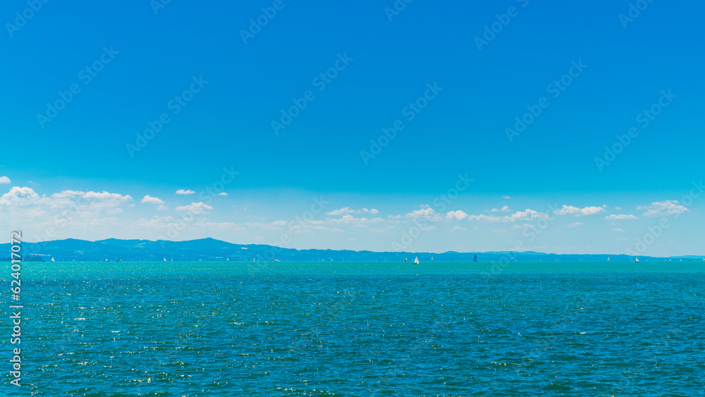 Germany, bodensee lake constance panorama view, sunny day, sailboats enjoying paradise nature landscape and water sport in summer with sun