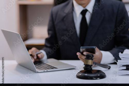 Asian lawyer working with contract at desk, justice and law concept.