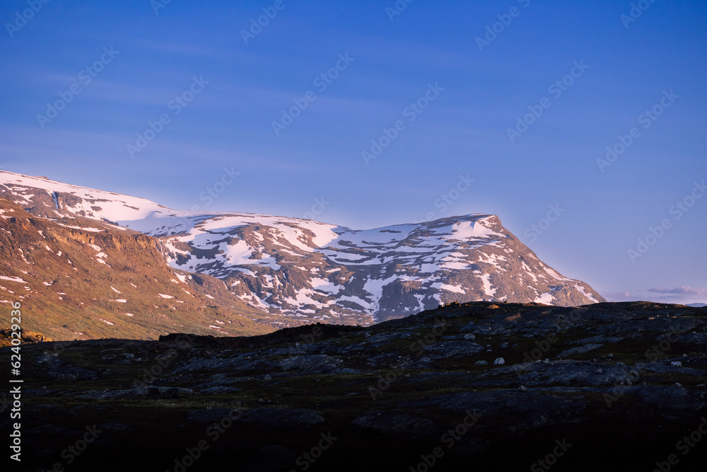 Midnight sun over mountains in remote harsh arctic landscape in Swedish Lapland. 