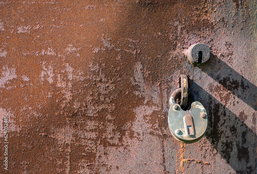 Rusty lock on a rusty metal door as a background.