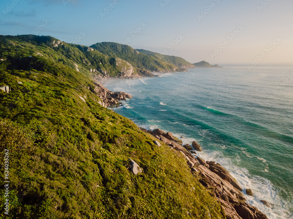 Coastline with ocean, waves and light haze at sunrise in Brazil. Aerial view