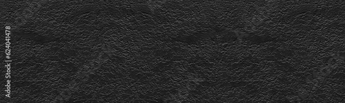 Black textured plaster wide wall. Dark rough cement texture. Gloomy grunge panoramic background