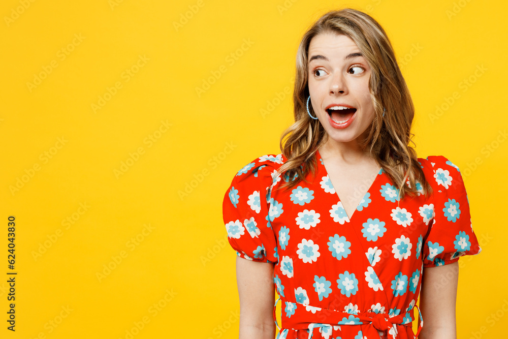 Young surprised shocked amazed happy excited fun caucasian woman she wear red dress casual clothes look aside with opened mouth isolated on plain yellow background studio portrait. Lifestyle concept. Young surprised shocked amazed happy excited fun caucasian woman she wear red dress casual clothes look aside with opened mouth isolated on plain yellow background studio portrait. Lifestyle concept.