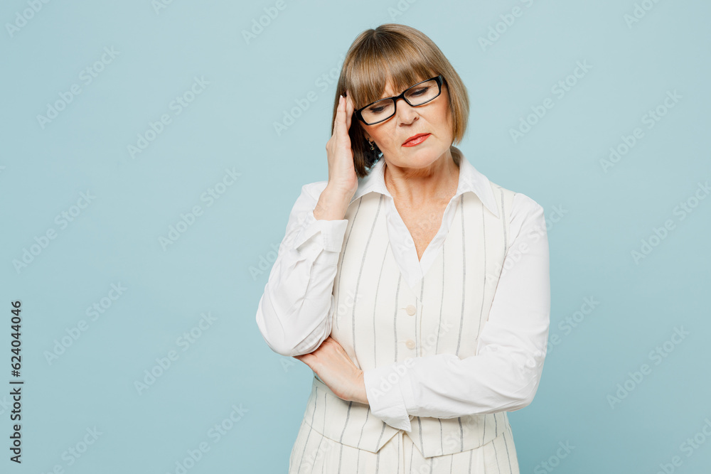 Blonde sad sick ill tired employee business woman 50s wears white classic suit glasses formal clothes put hand on forehead isolated on plain pastel light blue background. Achievement career concept. Blonde sad sick ill tired employee business woman 50s wears white classic suit glasses formal clothes put hand on forehead isolated on plain pastel light blue background. Achievement career concept.