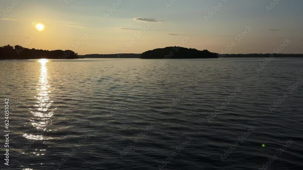 Sunset over the lake. Calm evening with the sun setting over the water in summer. Vacation time by the water. Sunset over the lake. Calm evening with the sun setting over the water in summer. Vacation time by the water.