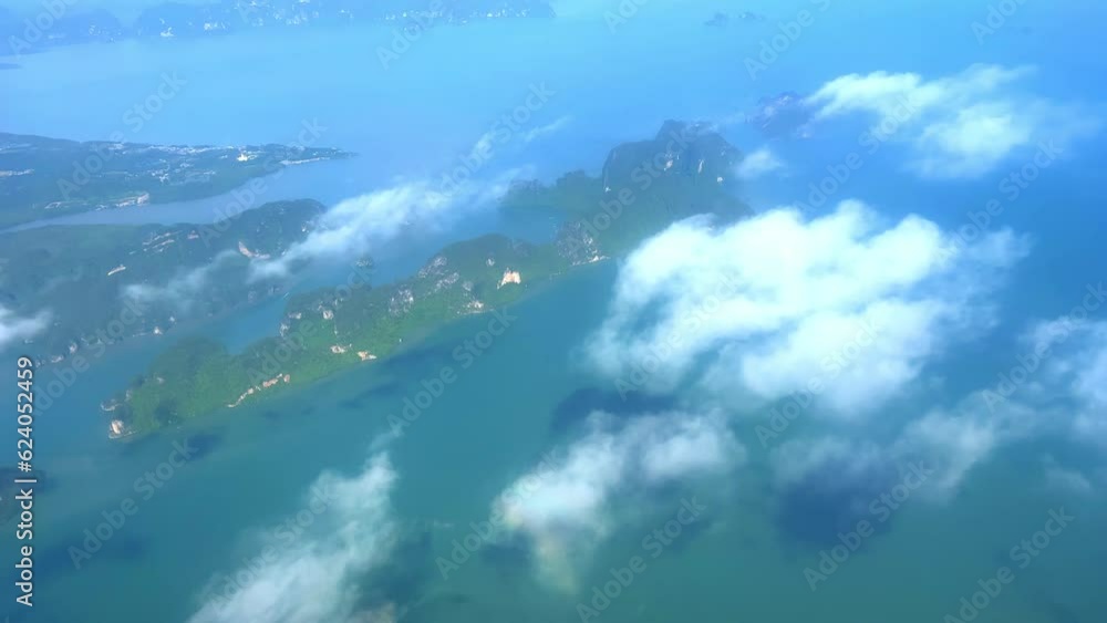 Flying over Phangna heading to phuket island airport with James Bond Islands below and clouds passing by fast phuket Thailand Flying over Phangna heading to phuket island airport with James Bond Islands below and clouds passing by fast phuket Thailand
